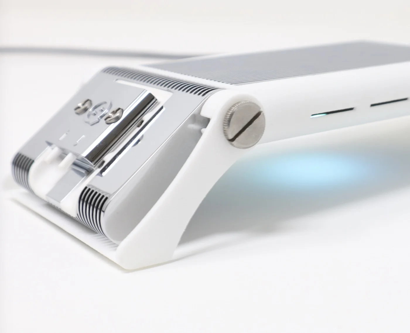 openQCM NEXT, close up: the chrome fluidic module in the white heat sink, the status light on